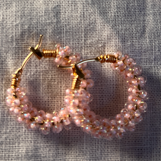 Beaded hoop earrings on a textured fabric background